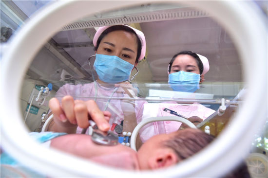 10月1日,在石家庄新乐市医院新生儿科,医护人员为一名婴儿做检查.