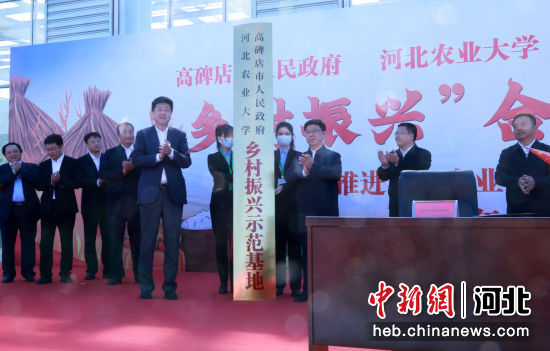 图为河北农业大学校长申书兴(右)与高碑店市委书记邱强共同为"乡村
